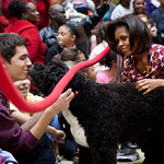 First Lady Michelle Obama and Bo, the Obama family dog, greet audience members at ChildrenÕs National Medical Center in Washington, D.C., Dec. 12, 2011. Mrs. Obama read "Twas the Night Before Christmas" during a Christmas holiday program with children, parents and staff. (Official White House Photo by Chuck Kennedy)  This official White House photograph is being made available only for publication by news organizations and/or for personal use printing by the subject(s) of the photograph. The photograph may not be manipulated in any way and may not be used in commercial or political materials, advertisements, emails, products, promotions that in any way suggests approval or endorsement of the President, the First Family, or the White House.Ê